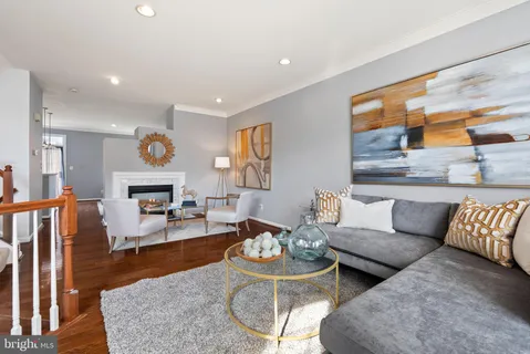a living room with furniture wooden floor and a large window