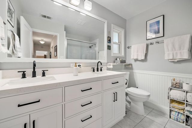 a bathroom with a double vanity sink mirror and toilet
