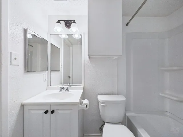 a bathroom with a sink a toilet and mirror
