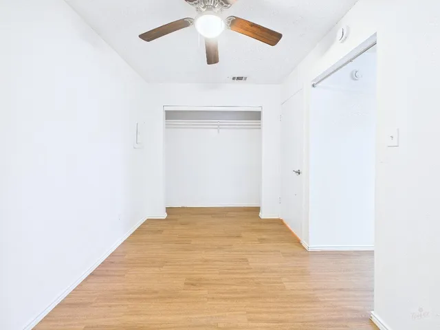 a view of empty room with wooden floor