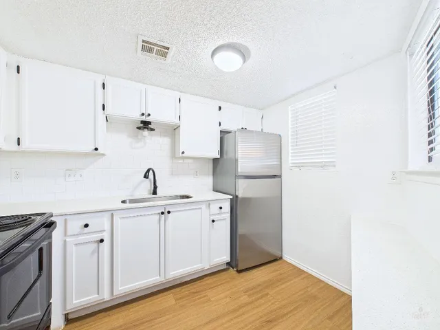 a kitchen with white cabinets and white appliances