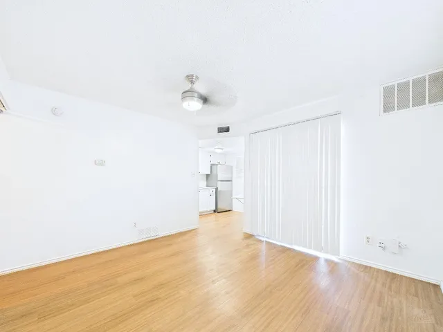 a view of an empty room with wooden floor