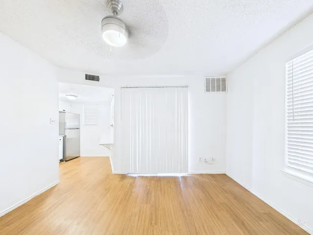 a view of a room with wooden floor and white walls