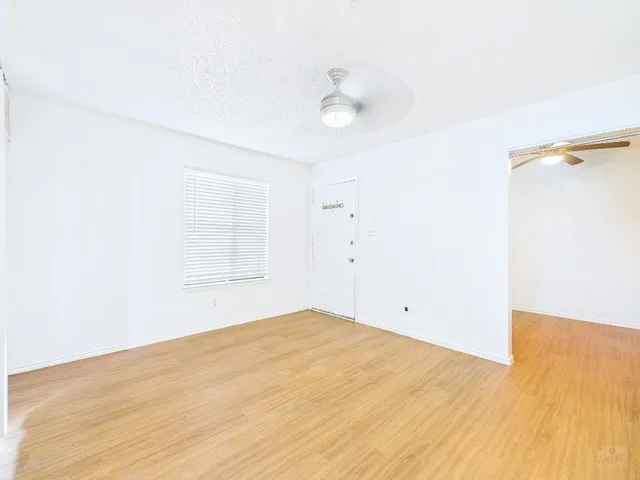 a view of empty room with wooden floor