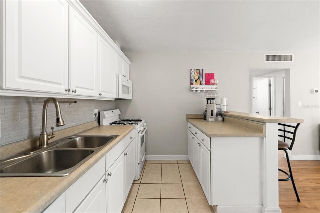1700 Southwest 16th Court, Unit D30 Gainesville, FL 32608 - Photo 8 of 22 a kitchen with a sink stove and cabinets