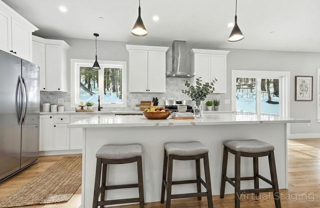 a kitchen with stainless steel appliances a sink a table and chairs