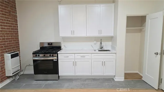 a kitchen with white cabinets and appliances