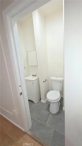 a white toilet sitting next to a white sink and vanity