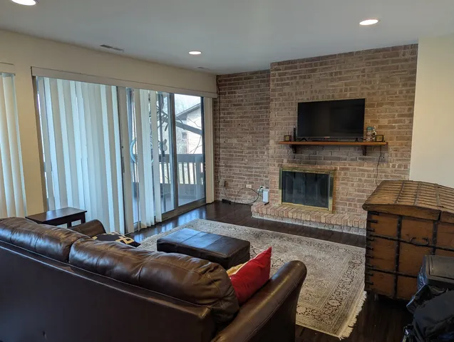 a living room with furniture a flat screen tv and a fireplace