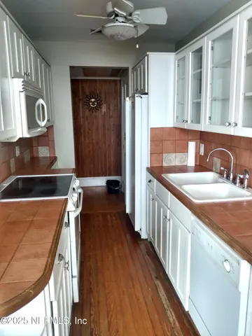 a kitchen with a sink and wooden floor
