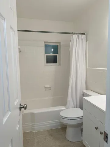 a bathroom with a shower a toilet and a sink