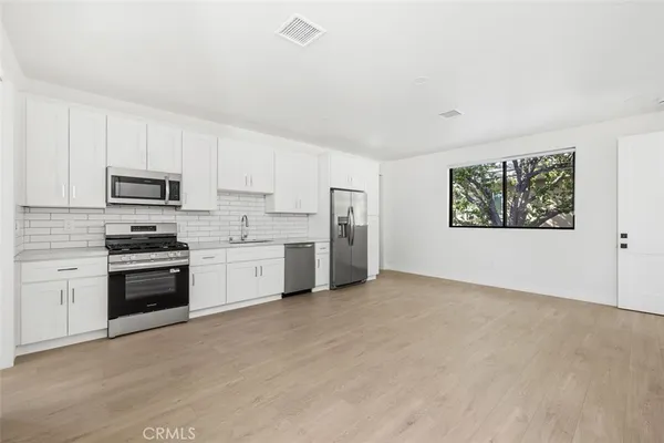 a kitchen with stainless steel appliances granite countertop a stove a sink and a refrigerator