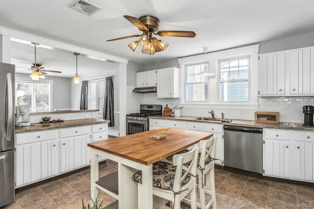 a kitchen with a stove a sink a refrigerator and cabinets