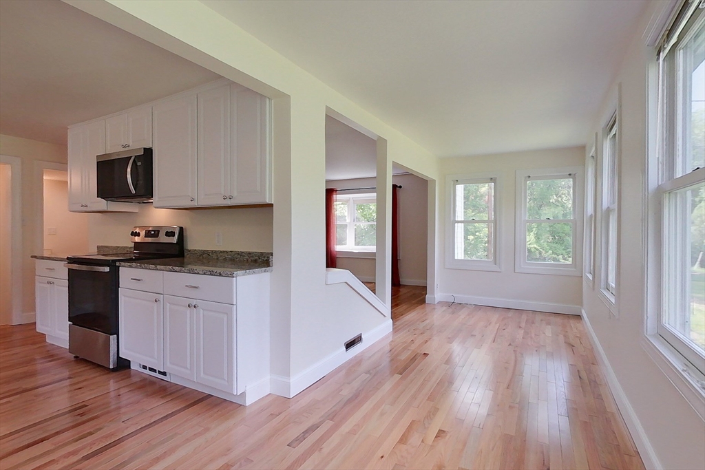 92 Squannacook Road Shirley, MA 01464 - Photo 6 of 38 a kitchen with wooden floors and white cabinets