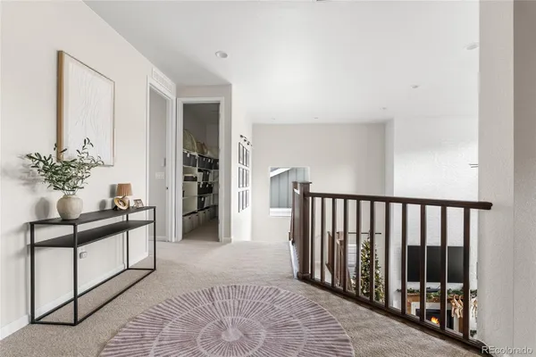 a view of a hallway to a livingroom with furniture and window