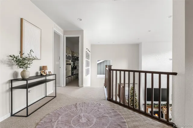 a view of a hallway to a livingroom with furniture and window