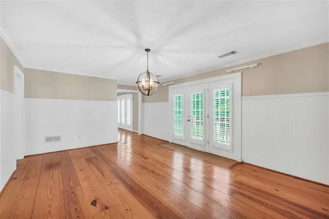 a view of a livingroom with wooden floor a ceiling fan and window