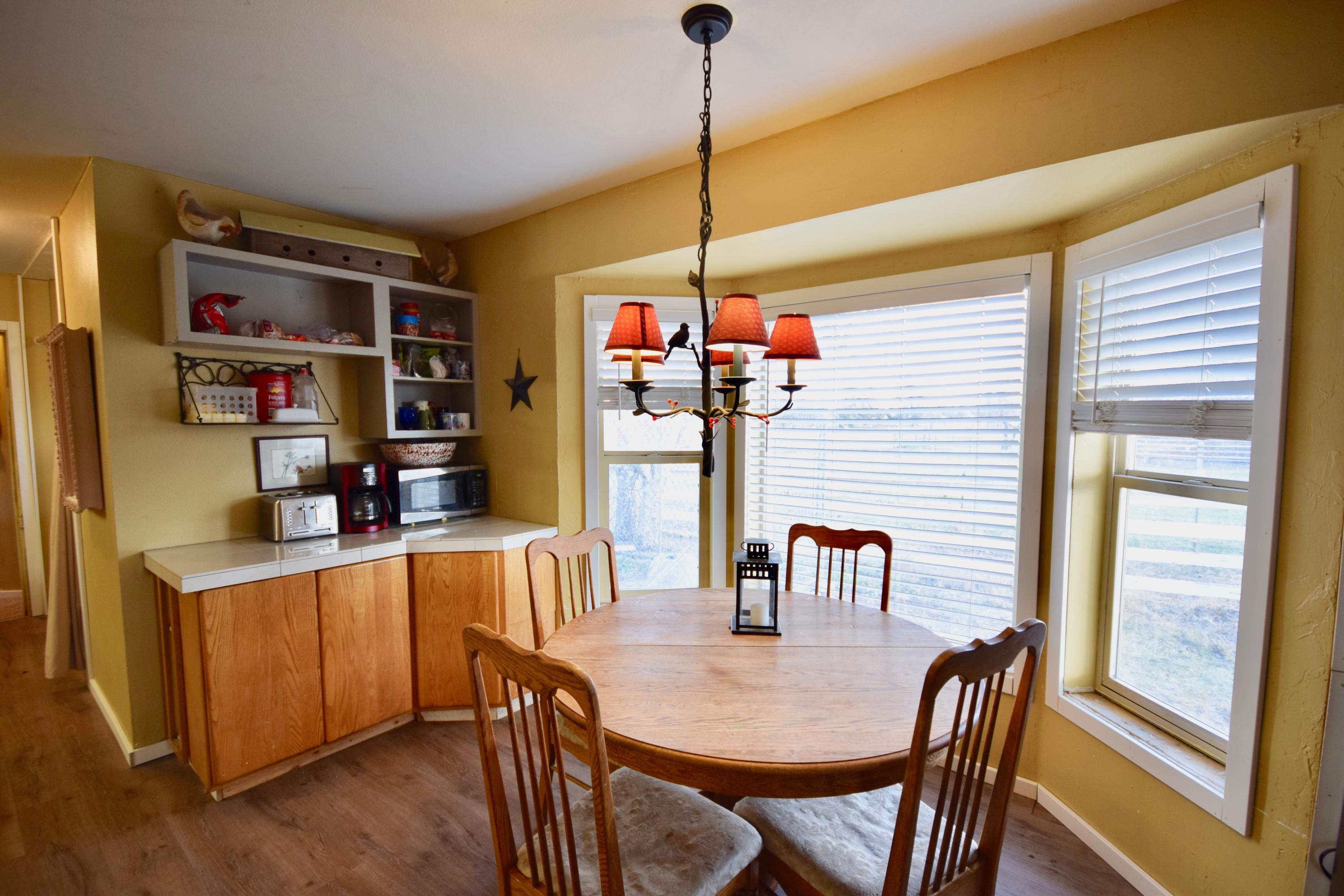 22169 Nelson Road Bend, OR 97701 - Photo 16 of 42 a dining room with stainless steel appliances kitchen island granite countertop a table chairs and a refrigerator