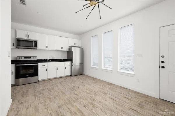 a kitchen with stainless steel appliances a stove a sink dishwasher a refrigerator and a microwave