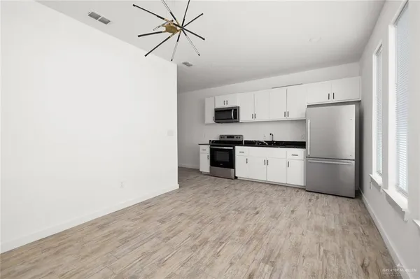 a kitchen with stainless steel appliances a refrigerator and a stove top oven