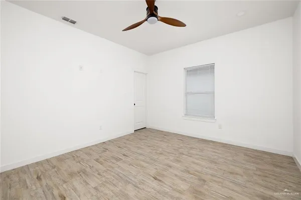 an empty room with a ceiling fan and carpet