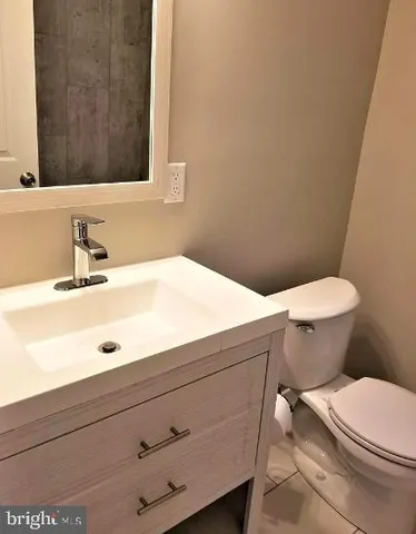 a bathroom with a sink a toilet and mirror
