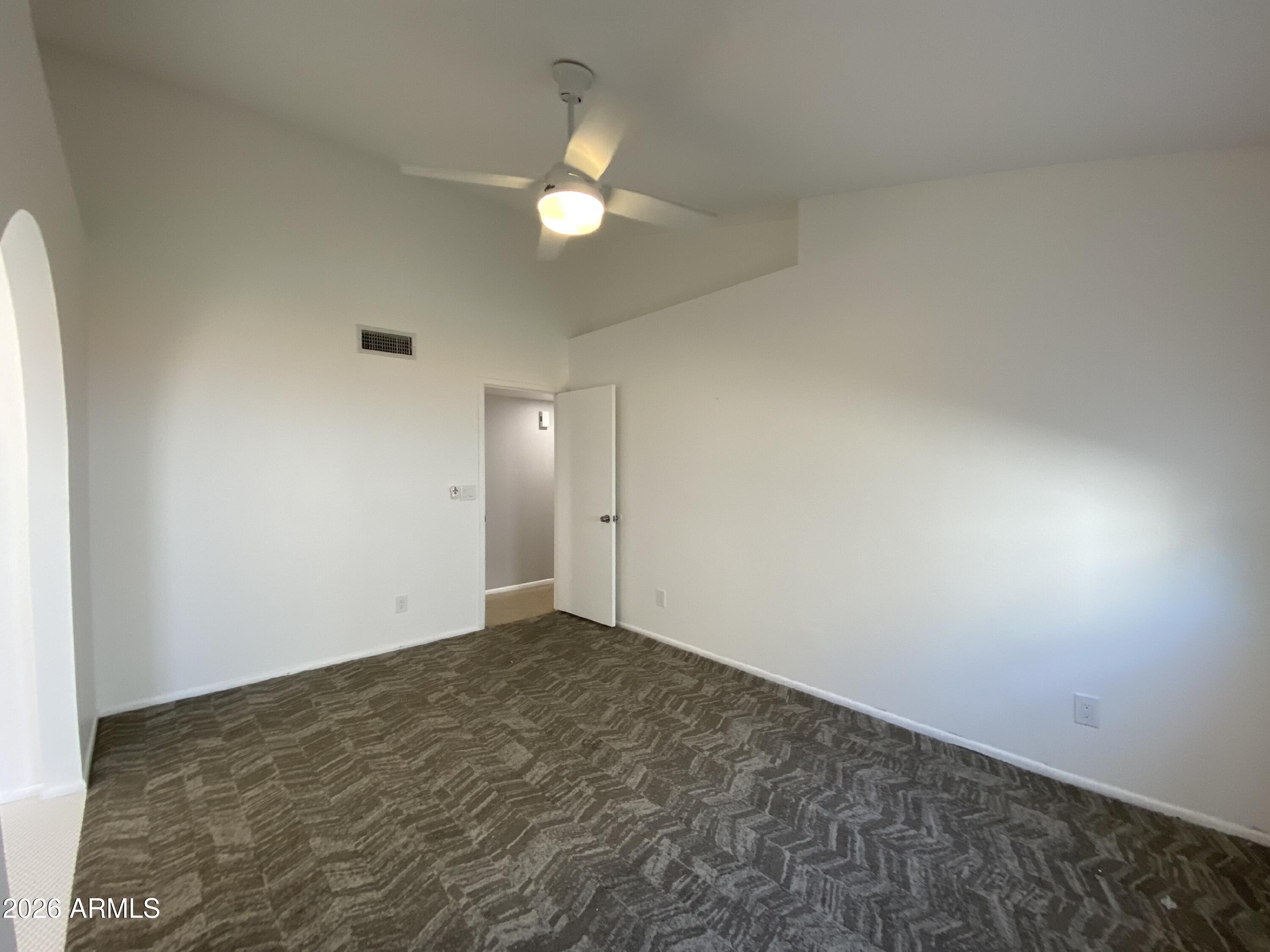 1055 North Recker Road, Unit 1196 Mesa, AZ 85205 - Photo 11 of 42 an empty room with a chandelier fan