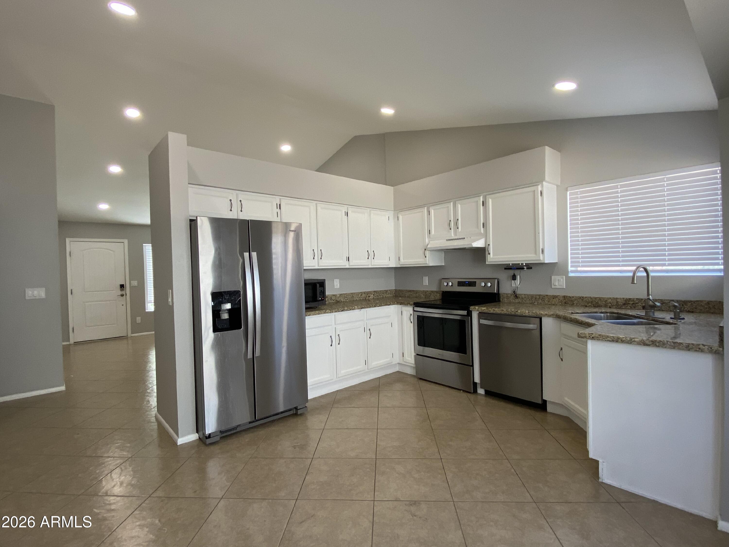 1055 North Recker Road, Unit 1196 Mesa, AZ 85205 - Photo 12 of 42 a large kitchen with stainless steel appliances granite countertop a stove a sink and a refrigerator
