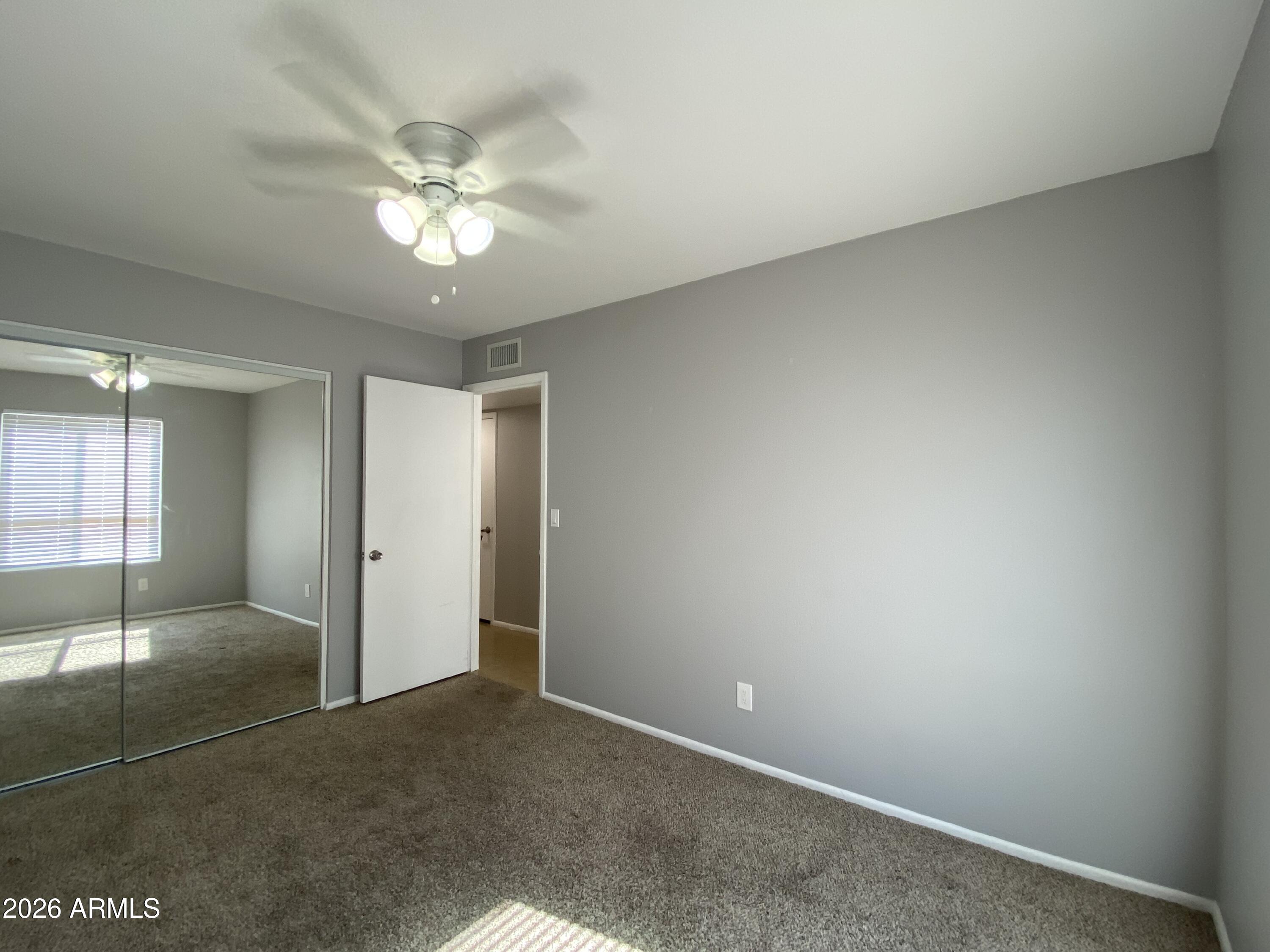 1055 North Recker Road, Unit 1196 Mesa, AZ 85205 - Photo 23 of 42 an empty room with fan and entrance