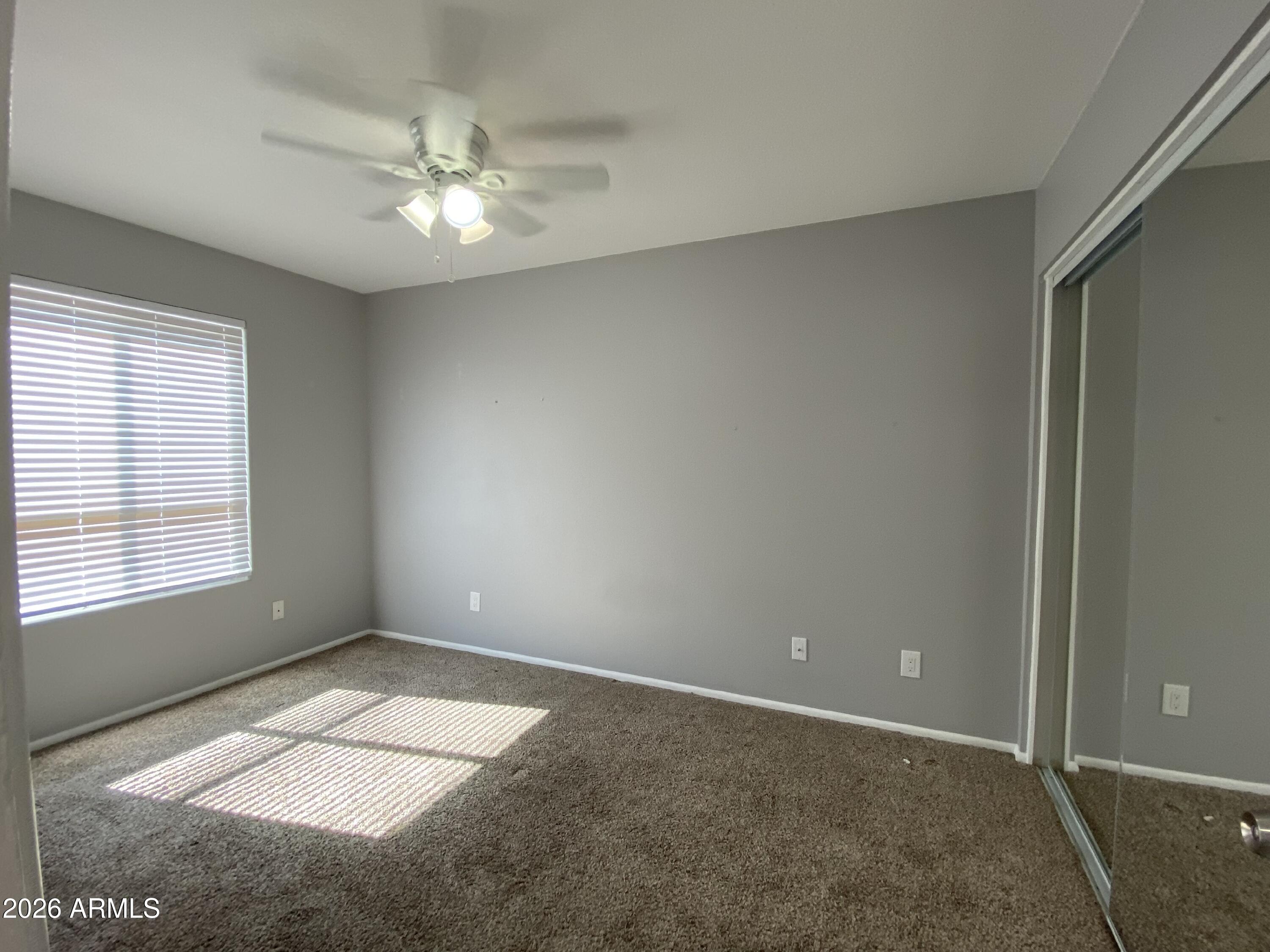 1055 North Recker Road, Unit 1196 Mesa, AZ 85205 - Photo 28 of 42 an empty room with windows and fan