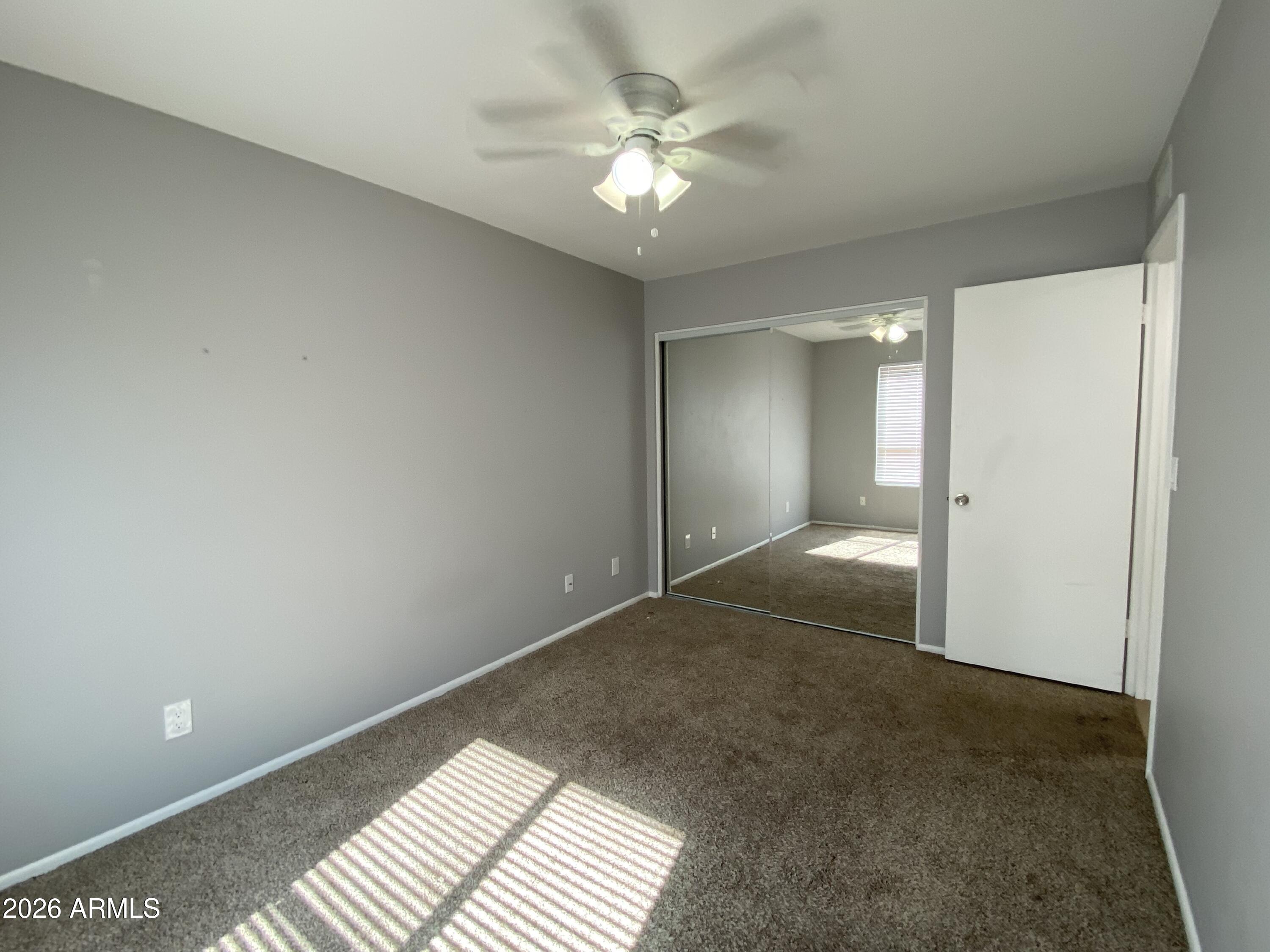 1055 North Recker Road, Unit 1196 Mesa, AZ 85205 - Photo 29 of 42 an empty room with an entryway and chandelier fan