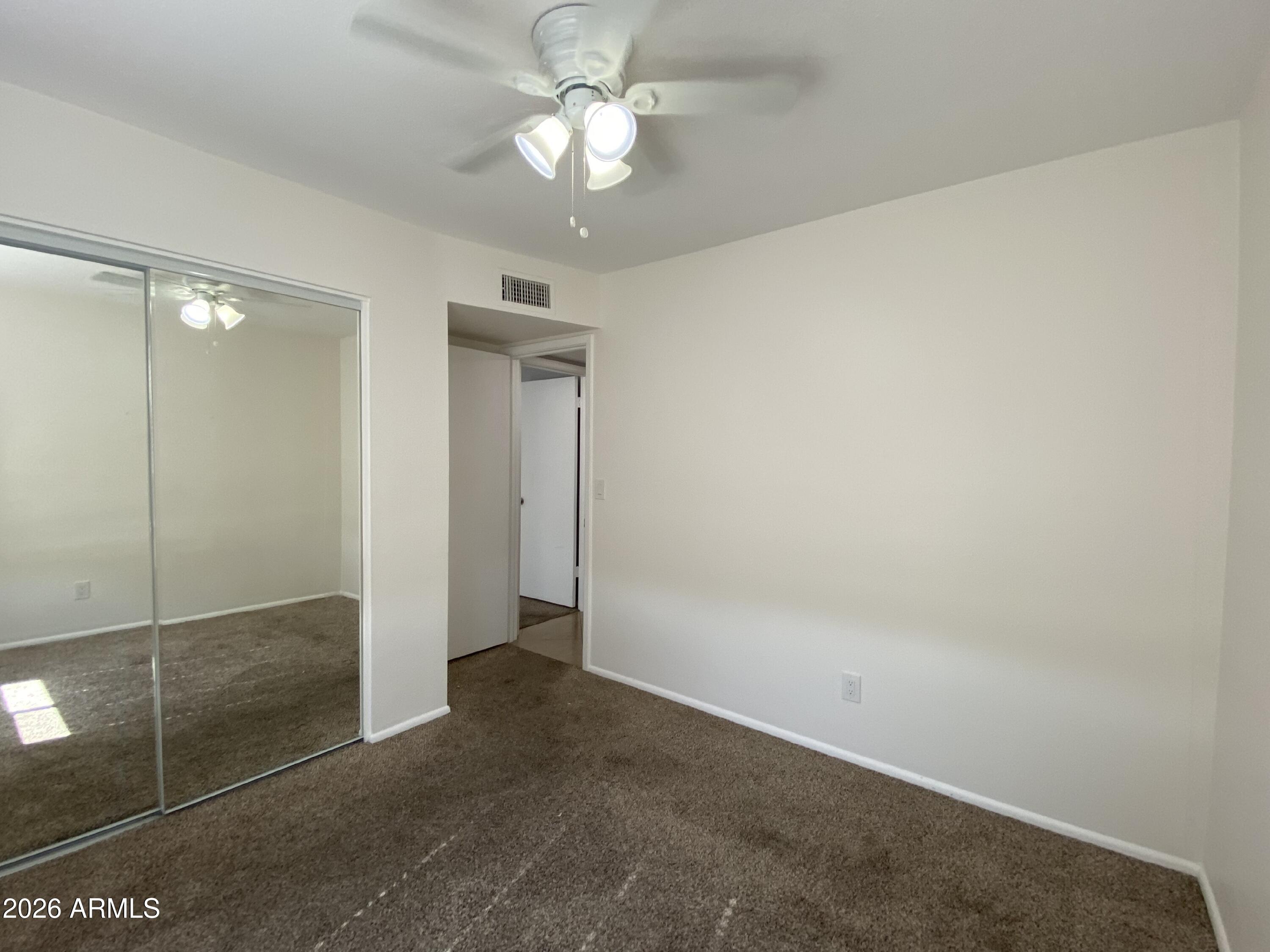 1055 North Recker Road, Unit 1196 Mesa, AZ 85205 - Photo 31 of 42 an empty room with a fan and a shower
