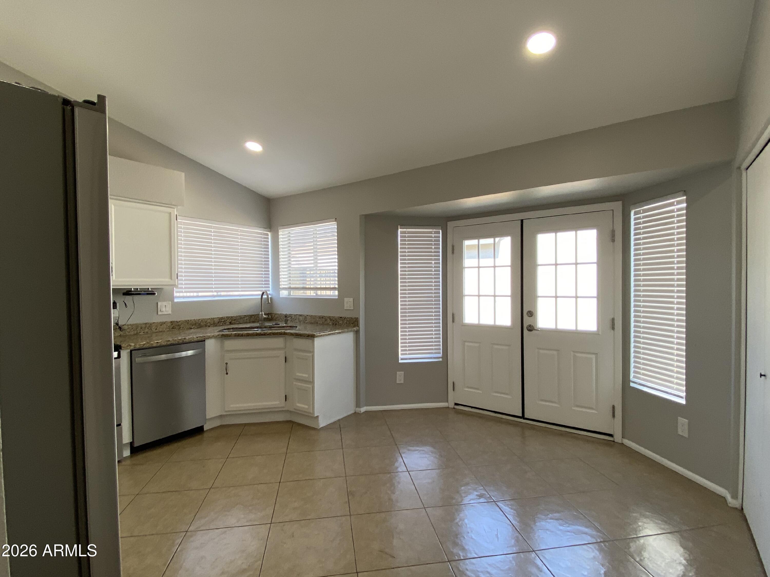1055 North Recker Road, Unit 1196 Mesa, AZ 85205 - Photo 4 of 42 a kitchen with granite countertop cabinets and window