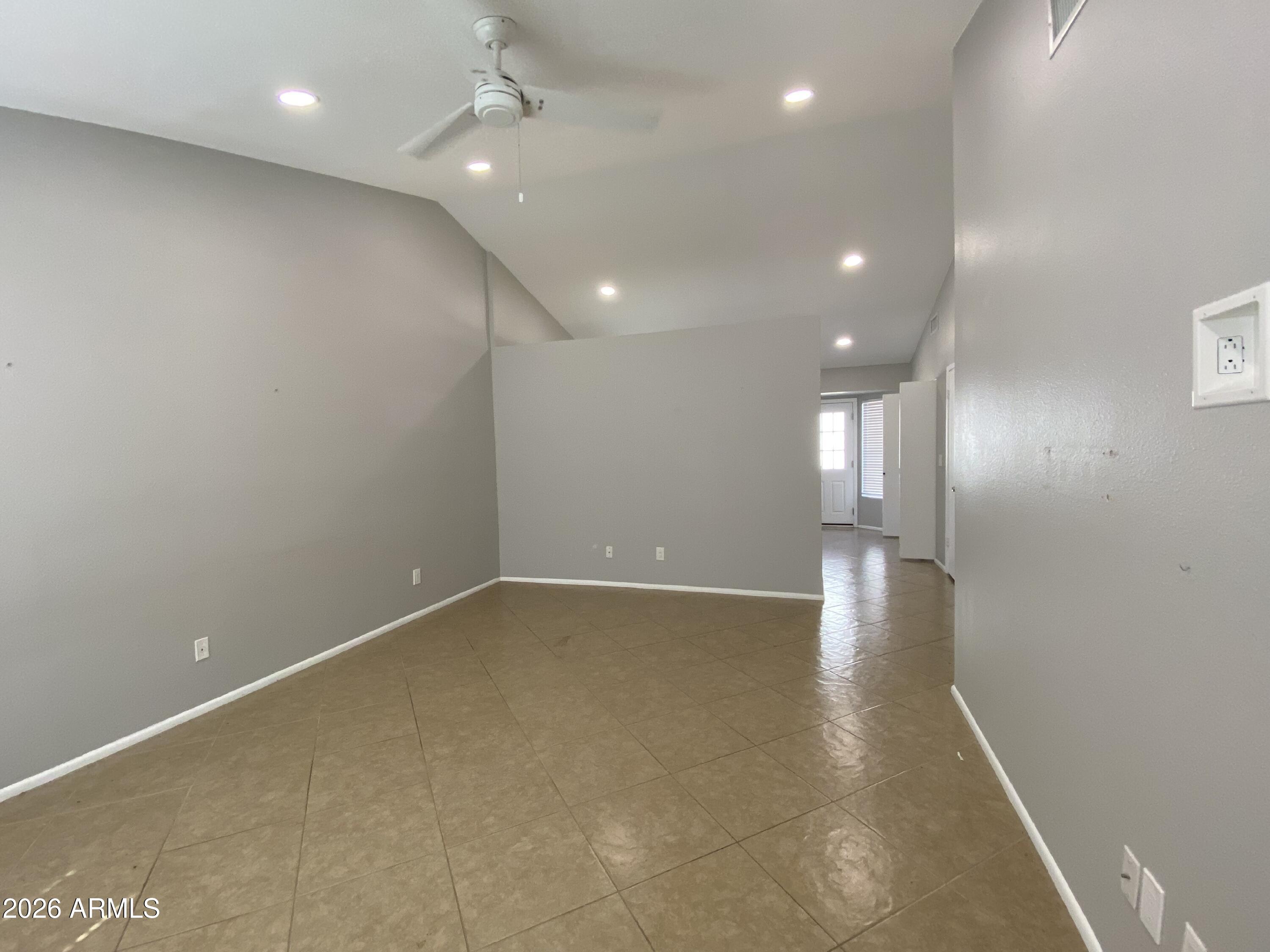 1055 North Recker Road, Unit 1196 Mesa, AZ 85205 - Photo 5 of 42 an empty room with wooden floor and windows