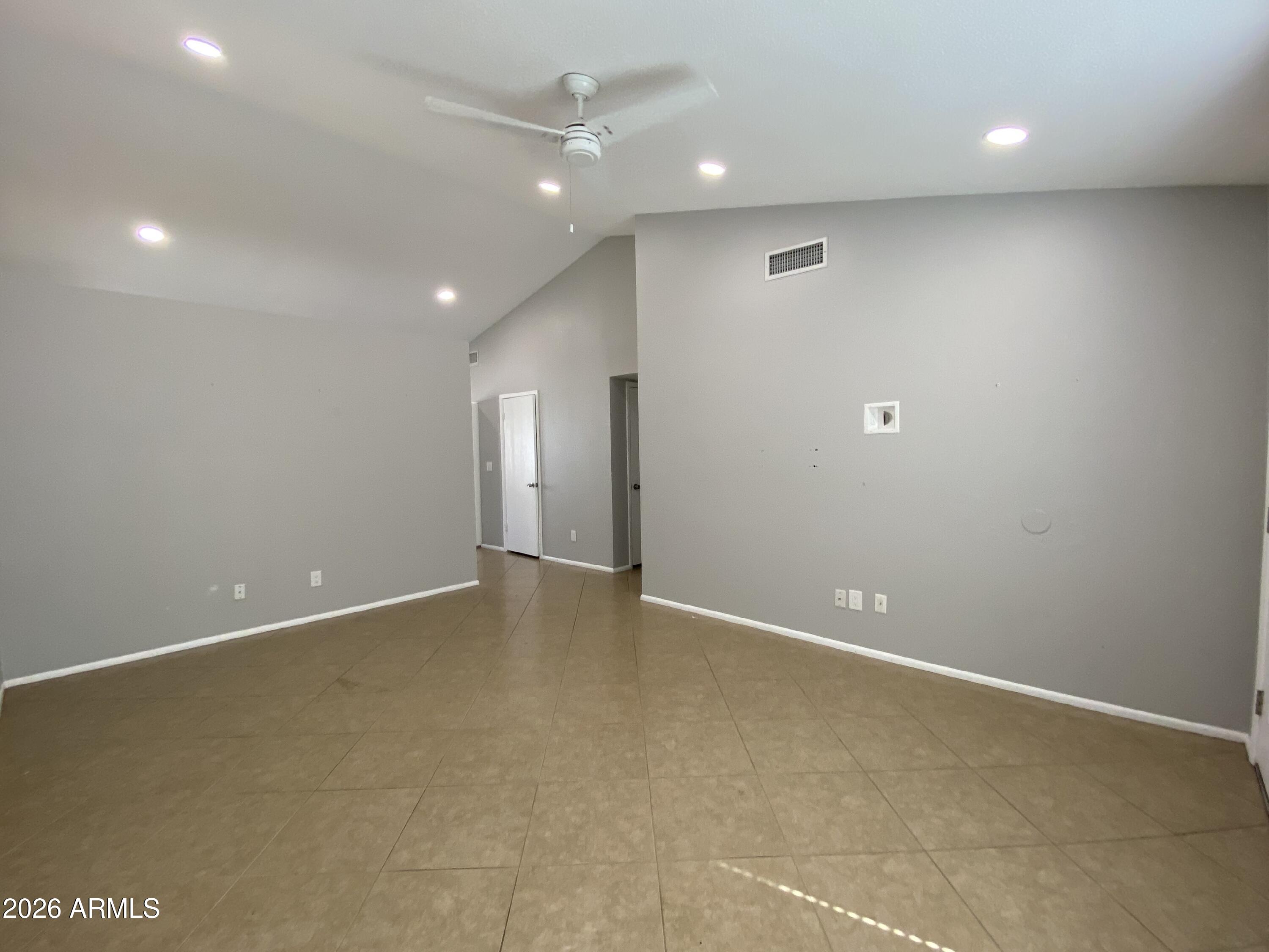 1055 North Recker Road, Unit 1196 Mesa, AZ 85205 - Photo 6 of 42 an empty room with wooden floor and windows