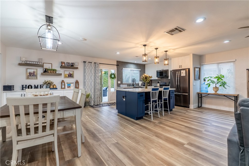 10328 Ivy Court Rancho Cucamonga, CA 91730 - Photo 24 of 40 a kitchen with stainless steel appliances kitchen island granite countertop a table chairs and a refrigerator