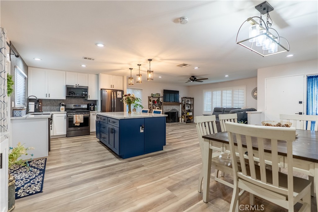10328 Ivy Court Rancho Cucamonga, CA 91730 - Photo 25 of 40 a large white kitchen with lots of counter space and chandelier
