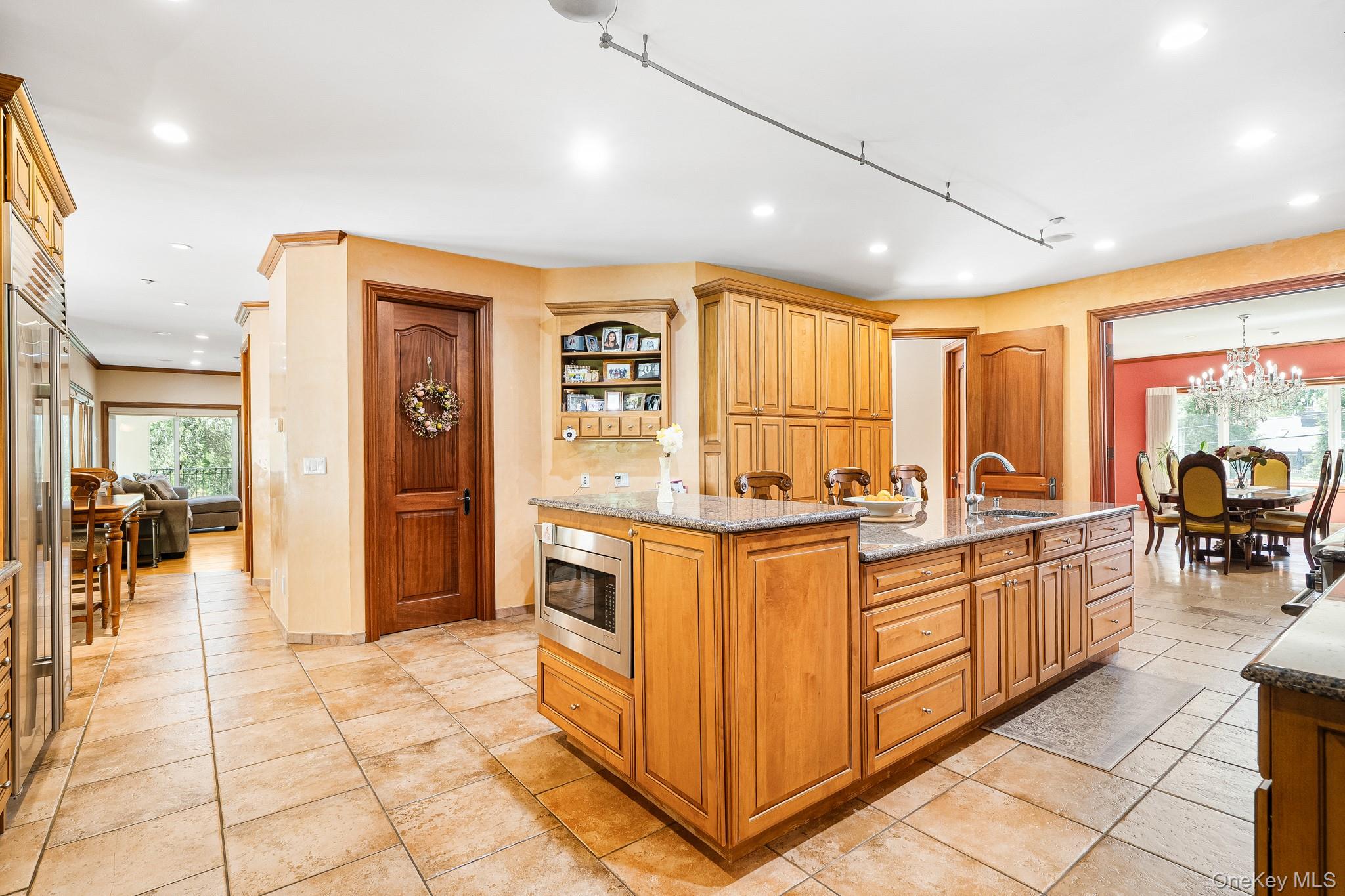 33 Winding Rd Farm Ardsley, NY 10502 - Photo 8 of 50 Kitchen featuring stainless steel microwave, recessed lighting, light stone counters, an island with sink, and a chandelier