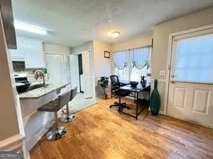 a work room with furniture a rug and a window