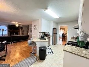 a kitchen with stainless steel appliances kitchen island granite countertop a sink stove and refrigerator