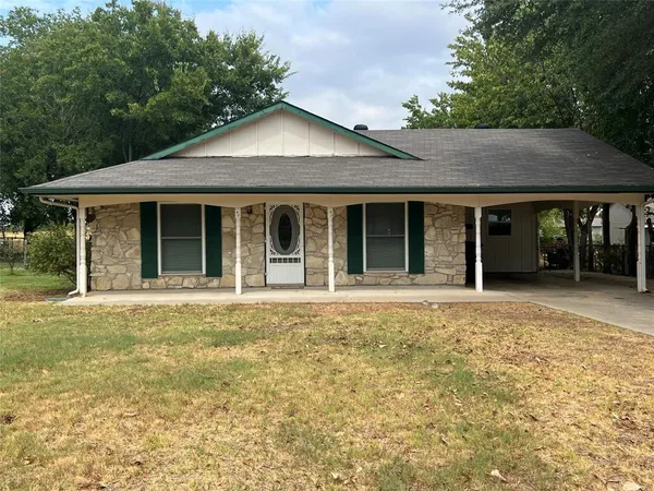 front view of a brick house with a yard
