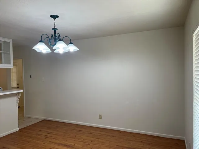 a view of a room with wooden floor and chandelier