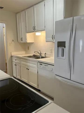 a kitchen with stainless steel appliances a refrigerator a sink and cabinets