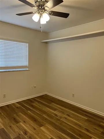 a view of a room with wooden floor and fan