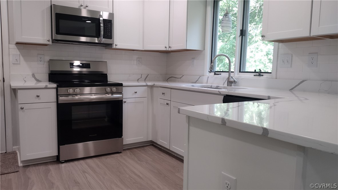 6000 Middlefield Place Chesterfield, VA 23832 - Photo 7 of 32 a kitchen with granite countertop a stove a sink and a microwave