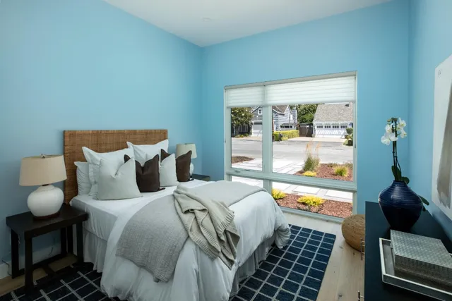 a bedroom with a bed and a large window