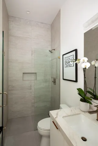 a bathroom with a sink a toilet and shower