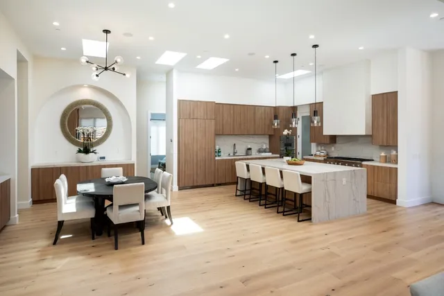 a large kitchen with kitchen island a island a sink stainless steel appliances and cabinets