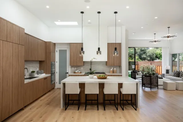 a kitchen with a table chairs stove and kitchen island with wooden floor