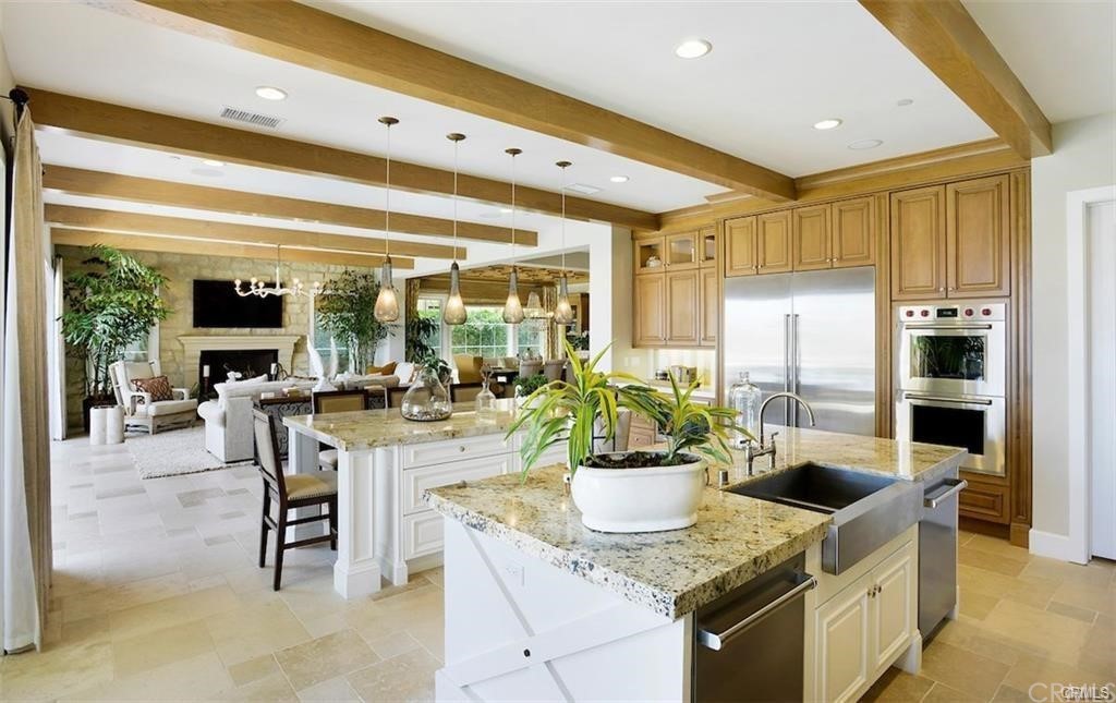 123 Amber Sky Irvine, CA 92618 - Photo 13 of 43 a dining hall with stainless steel appliances kitchen island granite countertop a table chairs and a refrigerator